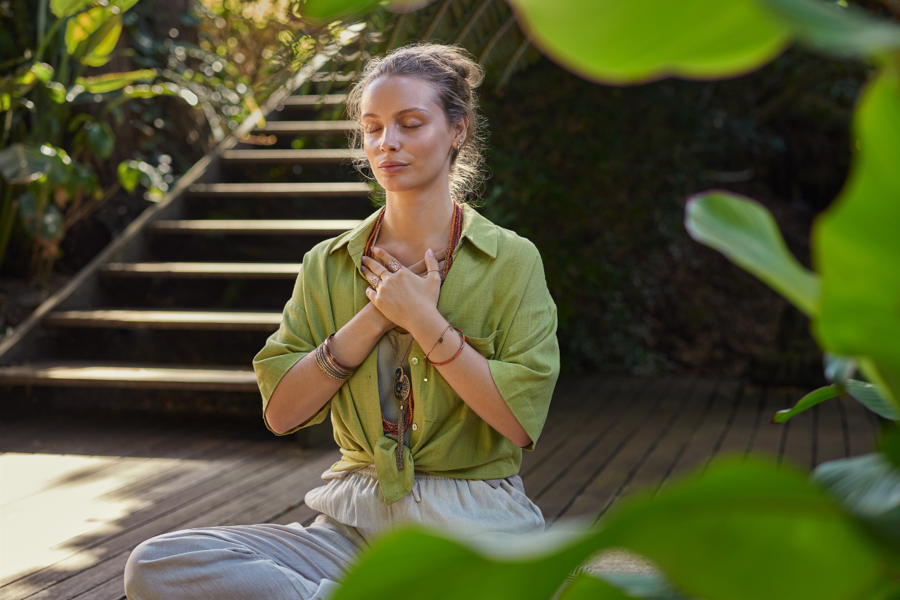 Woman resting a hand on her chest in a calm moment, representing hormonal health and PCOD wellbeing